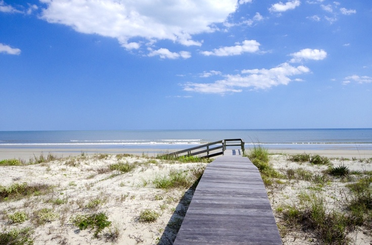 A serene boardwalk leading to the beach under a clear blue sky, the epitome of the best time to visit Kiawah Island as per the guide.