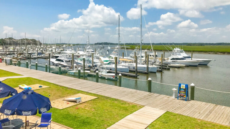 Waterfront shopping experience at The Shops at Bohicket Marina on Kiawah Island with yachts docked nearby.