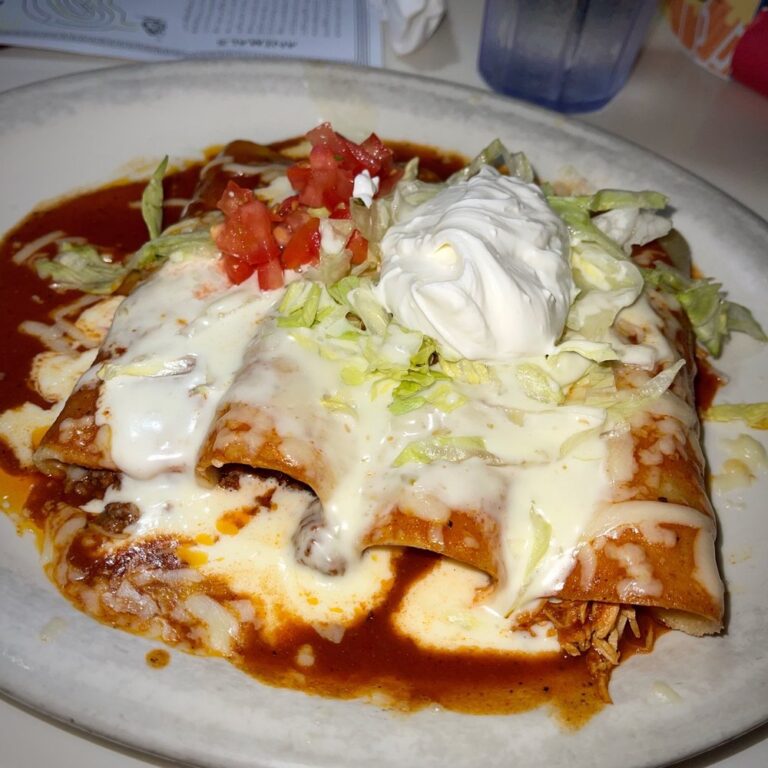 A plate of tantalizing enchiladas topped with melted cheese and sour cream at El Mercadito on Kiawah Island.