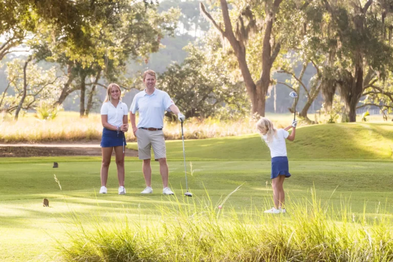 A family enjoys golfing together at Kiawah Island's Family Tee Time, perfect for creating bonding experiences for children and teens.