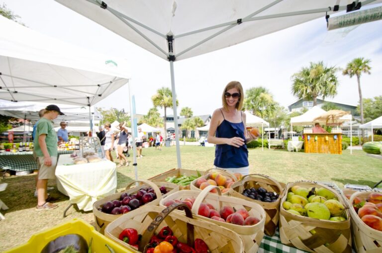 Visitors shopping at Freshfields Farmers Market on Kiawah Island, with a variety of fresh produce displayed.