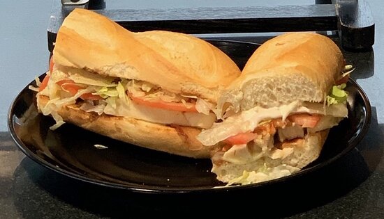 Freshly prepared deli sandwich from a Harris Teeter Deli, a popular dining option on Kiawah Island, served on a black plate.