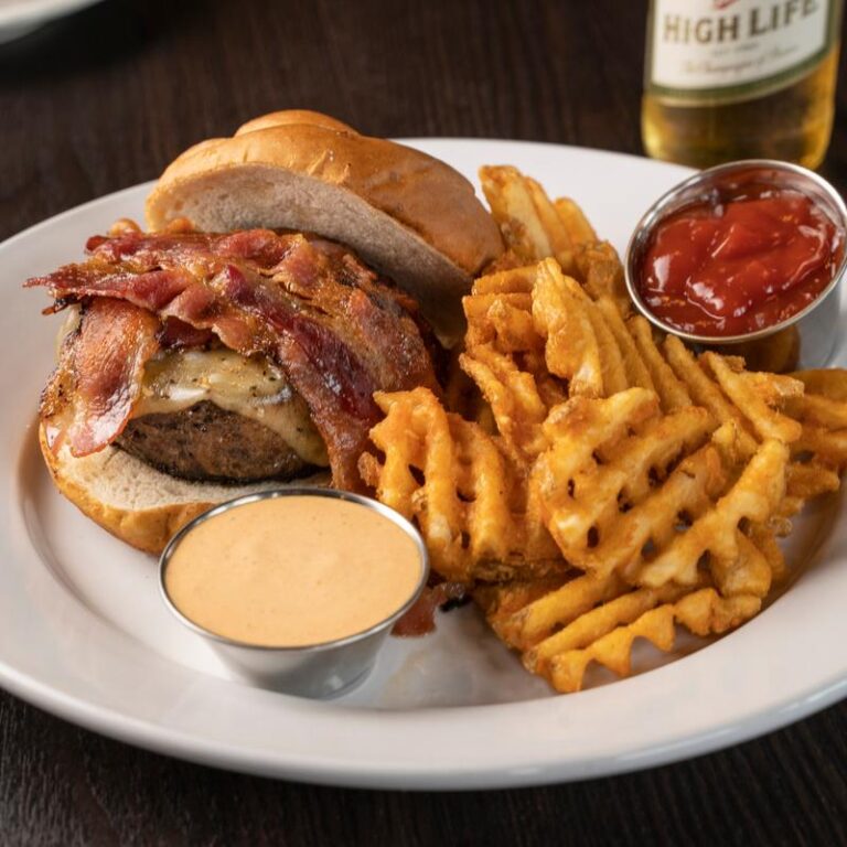 A classic bacon cheeseburger and waffle fries served at King Street Grille, a recommended casual sports bar on Kiawah Island.