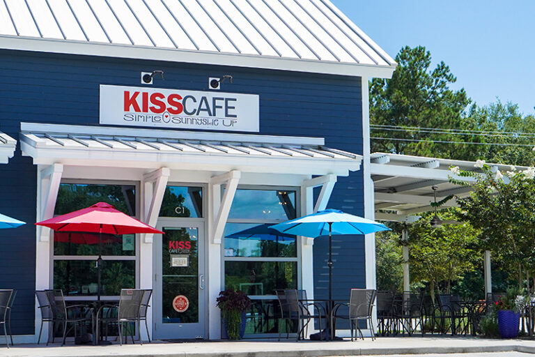 KISS Café's inviting exterior with blue umbrellas on Kiawah Island, where simple breakfasts turn into memorable mornings.