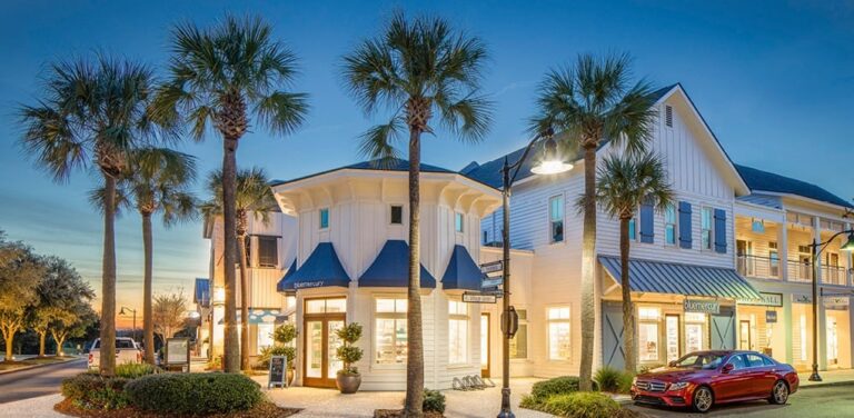 Twilight falls on an elegant shopping area lined with palm trees, featured in the Visit Kiawah Island Guide for shopping experiences.